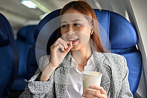 Attractive young asian businesswoman passenger taking pill of an airsick motion sickness