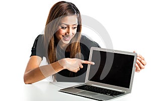 Attractive young asian indian teenage woman pointing at laptop