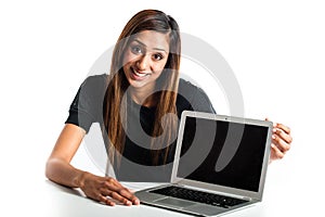 Attractive young asian indian teenage woman pointing at laptop