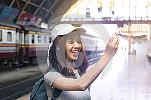 Attractive young Asian lady tourist with model airplane at train station. Travel lifestyle concept