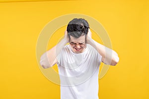 Attractive young asian man covering your ears loud noise shouting mouth angry and fury