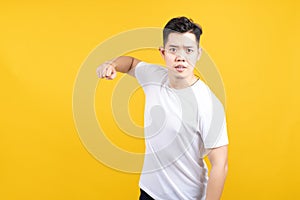 Attractive young asian man hold fist fury and angry negative emotion wearing white t-shirt