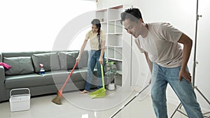 Attractive young Asian man and woman cleaning the house together happy family, beautiful