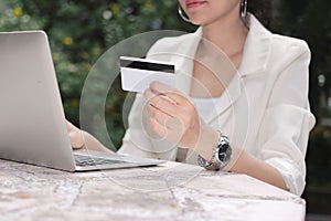 Attractive young Asian woman with laptop and credit card for shopping online