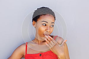 Attractive young black woman hand covering mouth