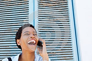 Attractive young black woman laughing with cell phone