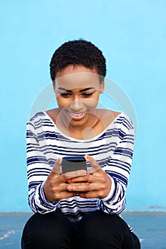 Attractive young black woman sitting with cell phone