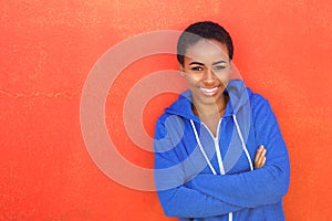 Attractive young black woman smiling against red background
