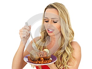 Attractive Young Blonde Haired Woman Eating a Freshly Baked Jacket Potato with Baked Beans