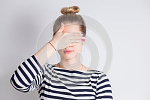 Attractive young blonde woman closing her eyes with hands. Portrait of beautiful girl, Surprise concept