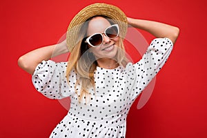 Attractive young blonde woman wearing everyday stylish clothes and modern sunglasses isolated on colorful background