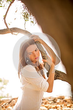 Attractive, young brunette on the beach, amid olive trees