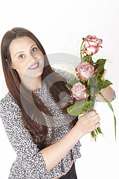 Attractive young brunette woman with bouquet of roses