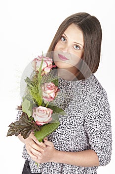 Attractive young brunette woman with bouquet of roses