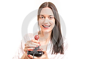 Attractive young brunette woman wearing a pink nightgown, laughing while operating a joystick