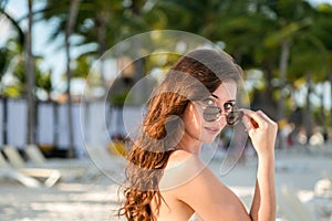 A attractive young brunette woman in a white summer dress on a beach in Mexico.