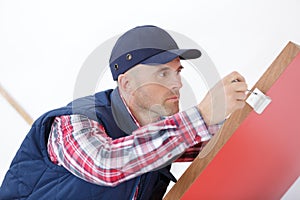 Attractive young builder installing lock in door