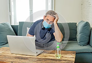 Attractive young business man on computer working from home feeling stressed, tired and overwhelmed