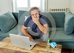 Attractive young business man on computer working from home feeling stressed, tired and overwhelmed
