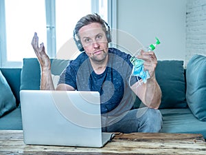 Attractive young business man on computer working from home feeling stressed, tired and overwhelmed