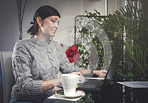 Attractive young business woman working from home with laptop