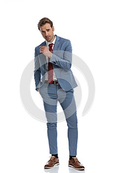 Attractive young businessman in blue suit holding hand in pocket