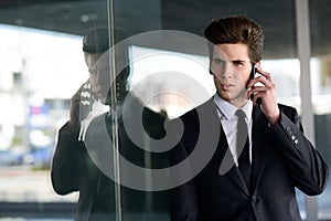 Attractive young businessman on the phone in an office building