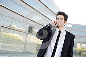 Attractive young businessman on the phone in an office building