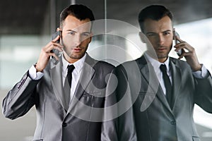 Attractive young businessman on the phone in an office building