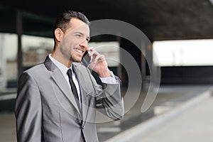 Attractive young businessman on the phone in an office building