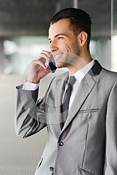 Attractive young businessman on the phone in an office building