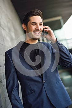 Attractive young businessman on the phone in an office building