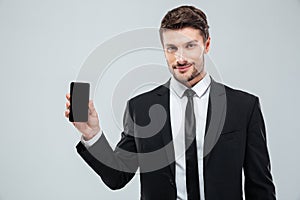 Attractive young businessman showing blank screen cell phone