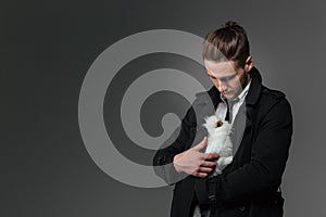 Attractive young businessman standing and holding rabbit