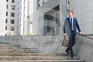 attractive young businessman in stylish suit with briefcase