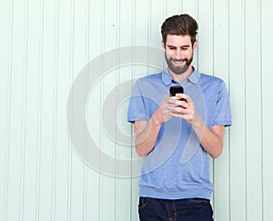 Attractive young casual man looking at mobile phone