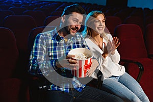 Attractive young caucasian couple watching a film at a movie theater