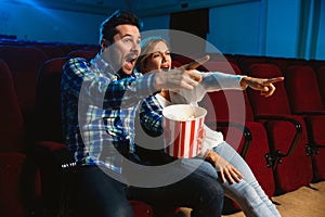 Attractive young caucasian couple watching a film at a movie theater