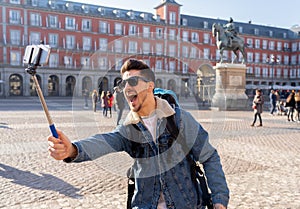 Handsome young student tourist man happy and excited taking a selfie in Madrid, Spain