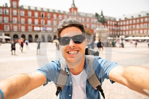 Handsome young caucasian tourist man happy and excited taking a selfie in Plaza Mayor, Madrid Spain photo