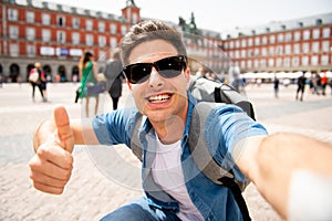 Handsome young caucasian tourist man happy and excited taking a selfie in Plaza Mayor, Madrid Spain photo