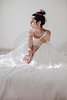 attractive young caucasian woman relaxing well in bed during morning time. Lady enjoys fresh soft bedding linen and mattress in