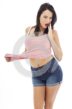 Attractive Young Caucasian Woman With Shocked Expression Pulling Seductively At Her Pink Vest Top