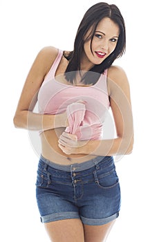 Attractive Young Caucasian Woman Wearing A Pink Vest Top and Blue Denim Shorts