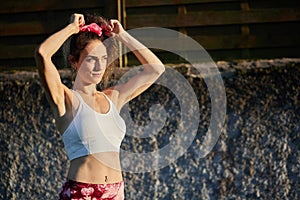 attractive young caucasican woman in sportswear leaning on a wall with sportwear