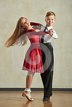 Attractive young couple of children dancing ballroom dance