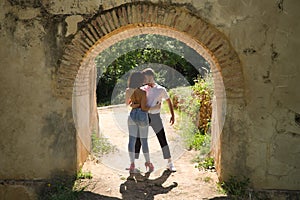 Attractive young couple dancing sensual bachata under an ancient stone arch in an outdoor park. Latin, sensual, folkloric, urban