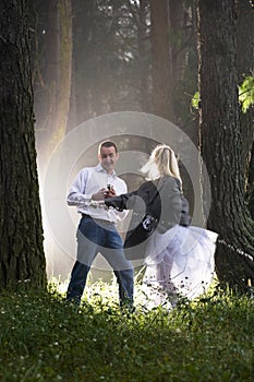 Attractive young couple having fun in misty forest