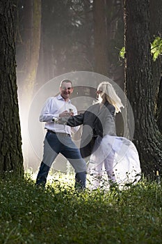 Attractive young couple having fun in misty forest