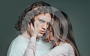 Attractive young couple hugging each other on grey background. Young man and woman in cuddle. Young sexy couple. Close